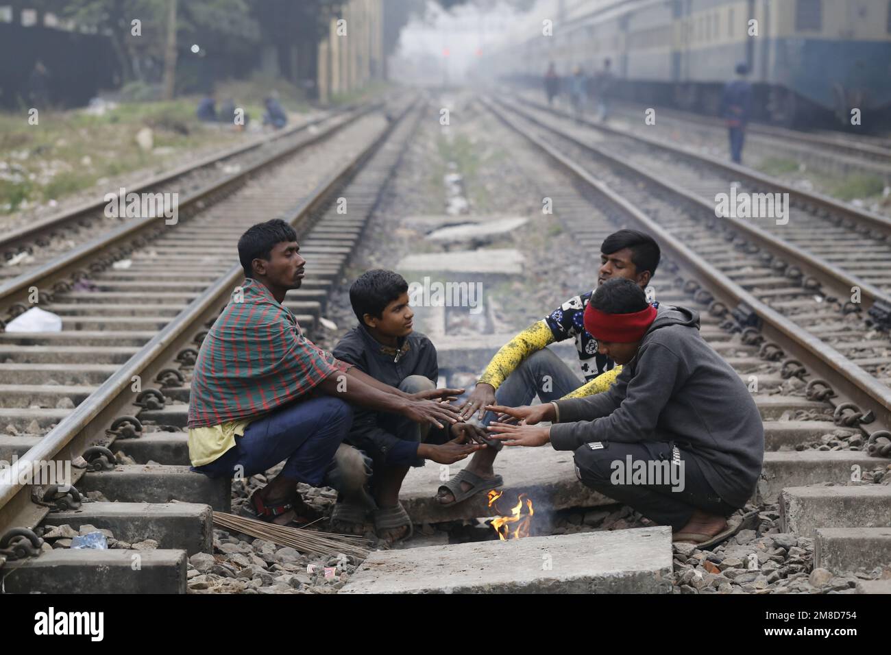 Les hommes ont mis en place un feu de camp pour se maintenir au chaud pendant un hiver froid à Dhaka, au Bangladesh, sur 4 janvier 2023. Banque D'Images