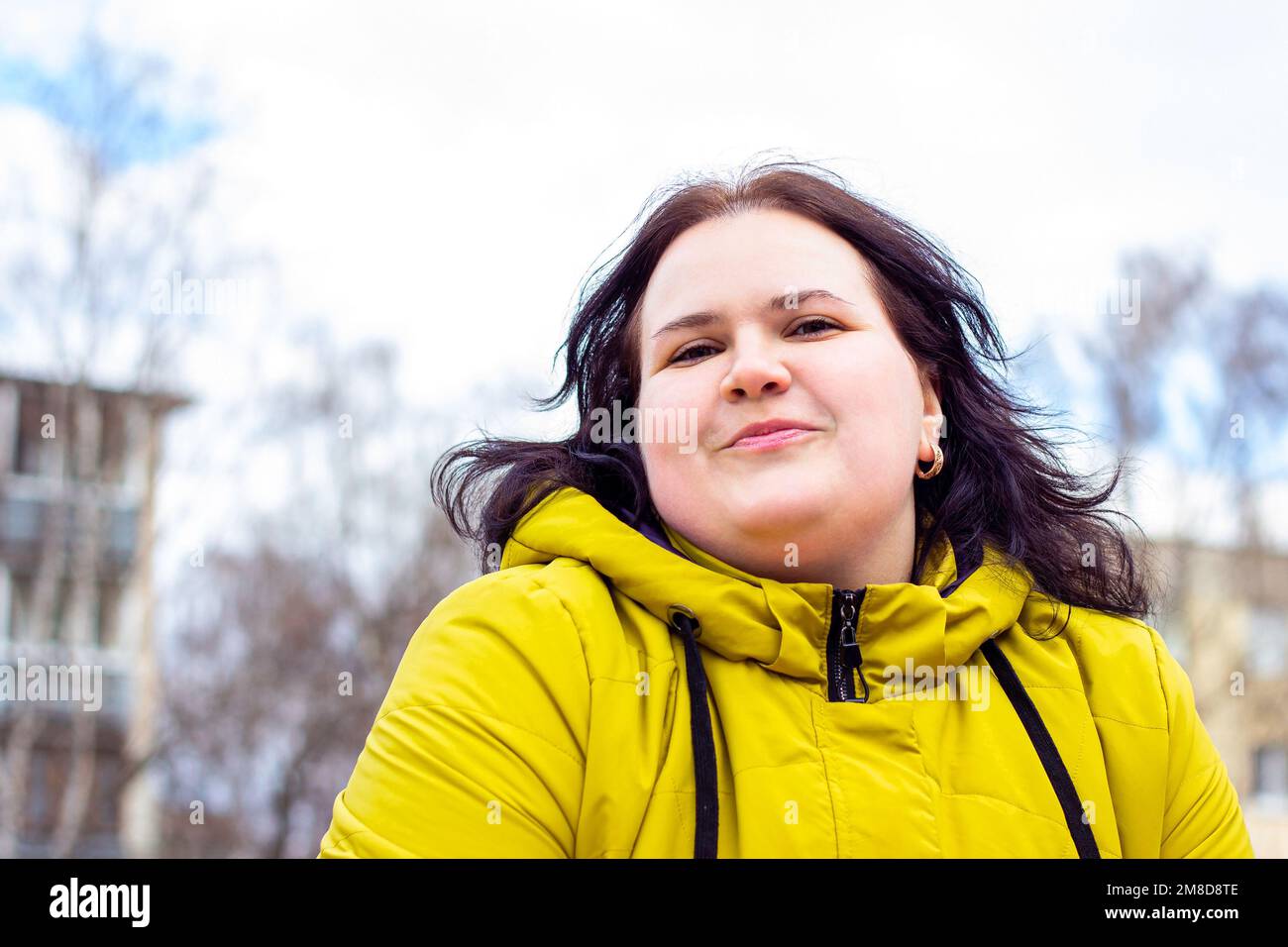 Heureux attrayant chubby surpoids femme caucasienne souriant portrait à l'extérieur. Une personne joyeuse, plutôt positive pour le corps, riant pendant la promenade dans le parc. Banque D'Images