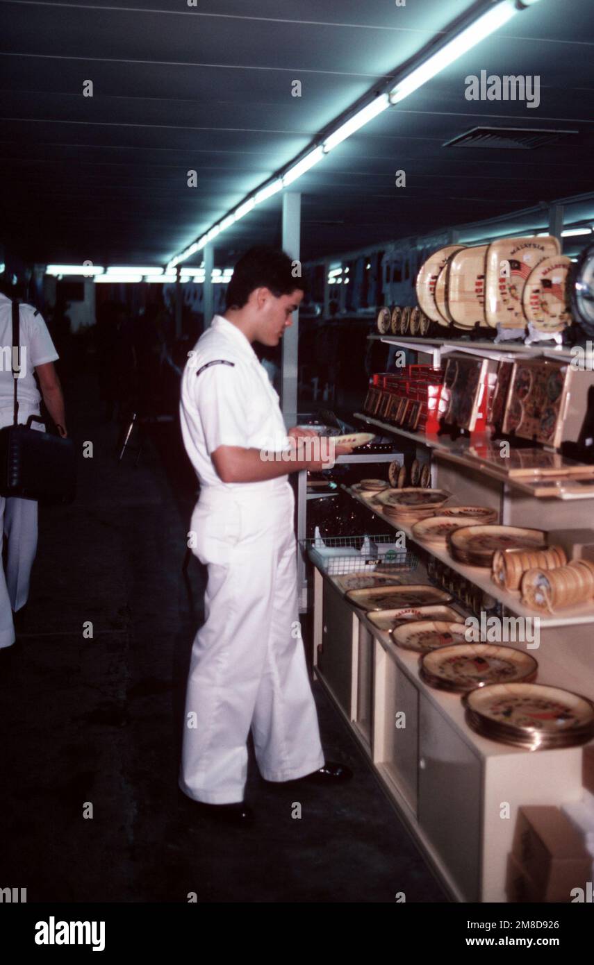 Radioman 3rd classe Robinson Acosta inspecte des souvenirs lors d'une visite de la station. Robinson est membre d'équipage à bord du croiseur à missiles guidé USS BUNKER HILL (CG 52), l'un des plus de soixante navires de vingt pays réunis pour l'examen international de la flotte en l'honneur du 55th anniversaire de la Marine royale malaisienne. Base: Georgetown pays: Malaisie (MYS) Banque D'Images