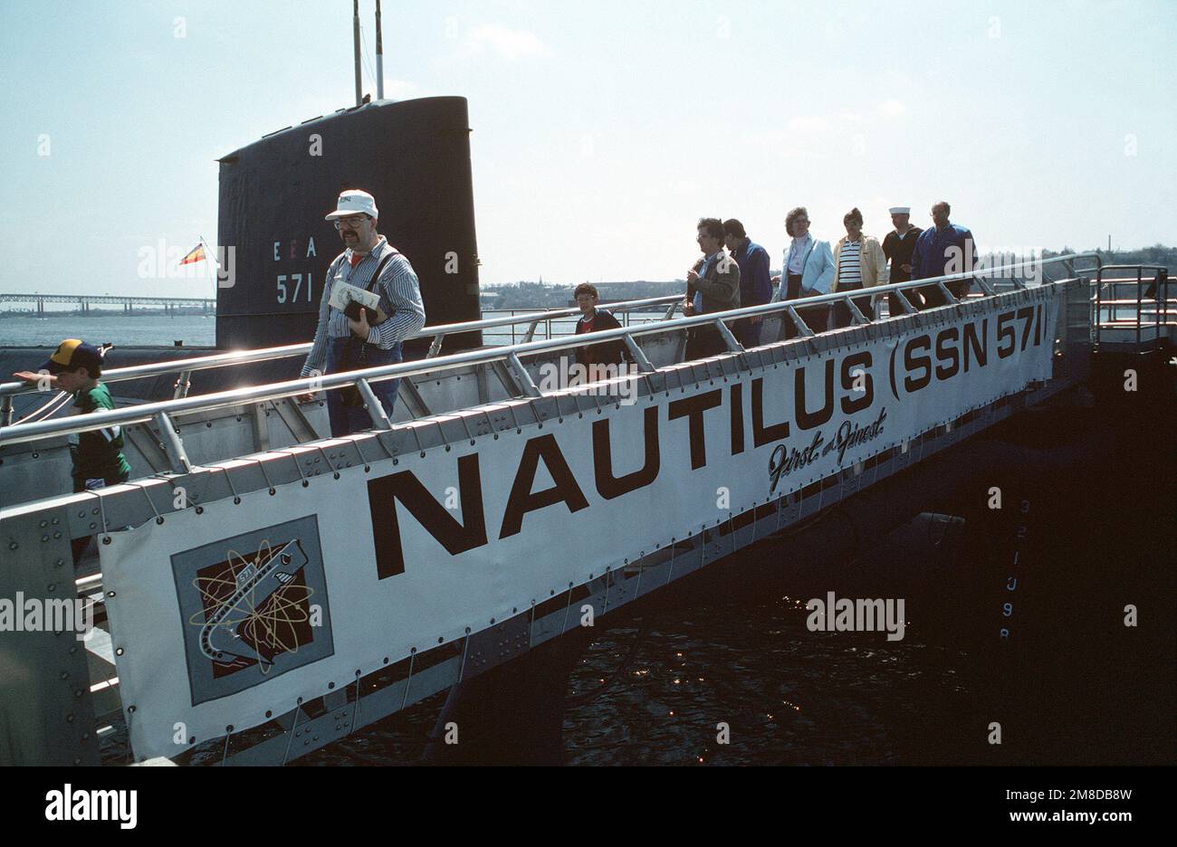 Les touristes descendent le front jusqu'à la jetée après avoir visité le sous-marin NUCLÉAIRE NAUTILUS (SSN 571). Le NAUTILUS, le premier sous-marin nucléaire de la Marine, a été officiellement désigné comme un site historique national en mai 1982. Base : base navale sous-marine, Groton État : Connecticut (CT) pays : États-Unis d'Amérique (USA) Banque D'Images