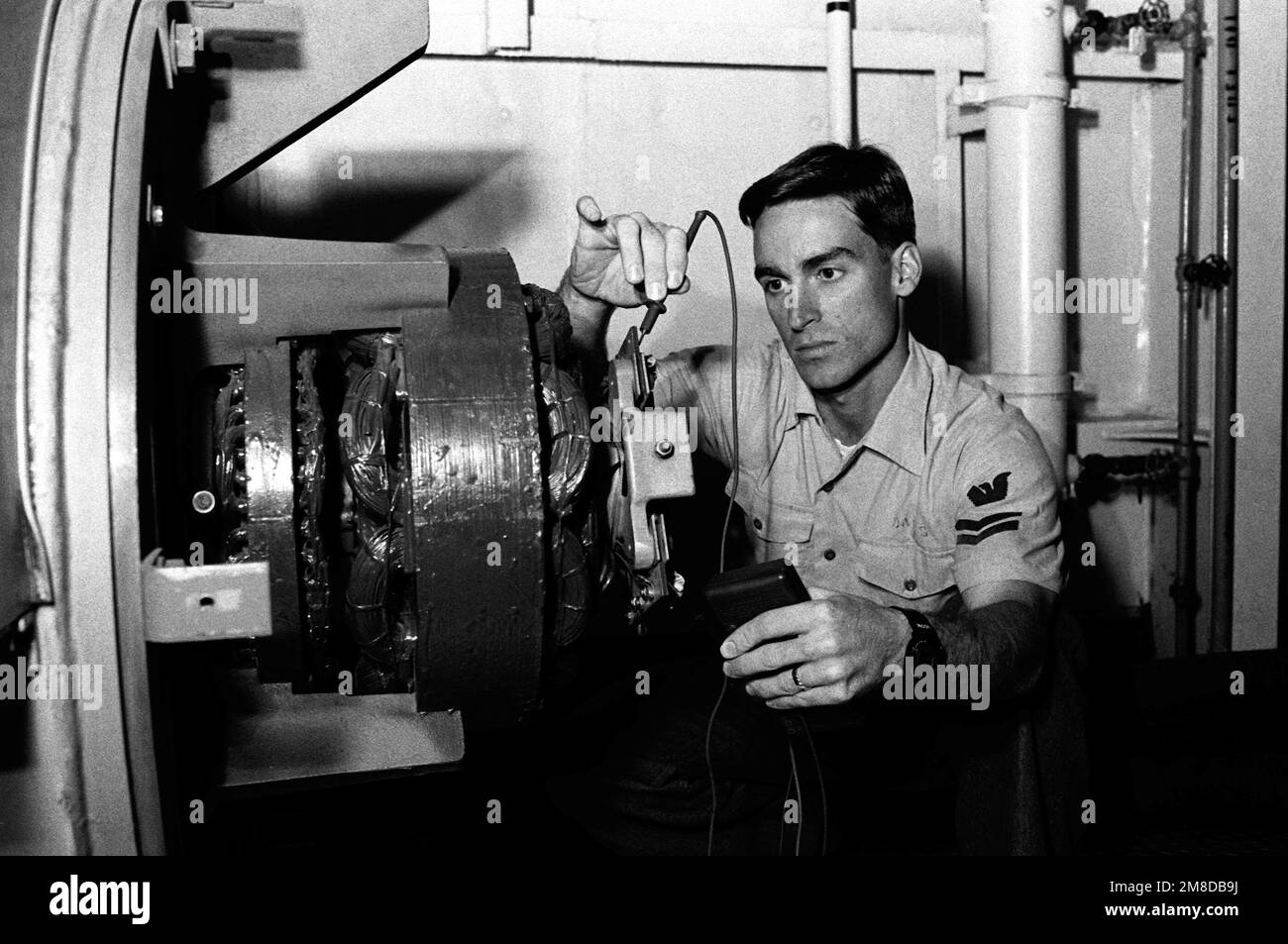 Le Mate 2nd Class Mark Davis d'électricien, « l'aieur de l'année » pour le SOUTE de quai sec flottant auxiliaire moyen (AFDM-7), utilise un testeur de tension pour vérifier un générateur. Base: Naval Air Station, Norfolk État: Virginie (va) pays: Etats-Unis d'Amérique (USA) Banque D'Images