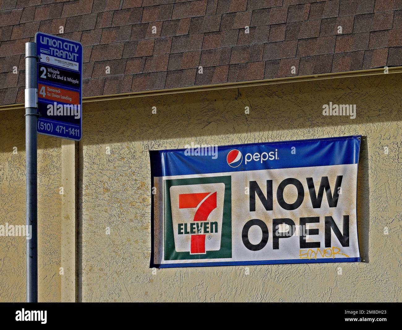 Le magasin Seven Eleven ouvre maintenant un panneau à un arrêt de bus Union City Transit, Californie Banque D'Images