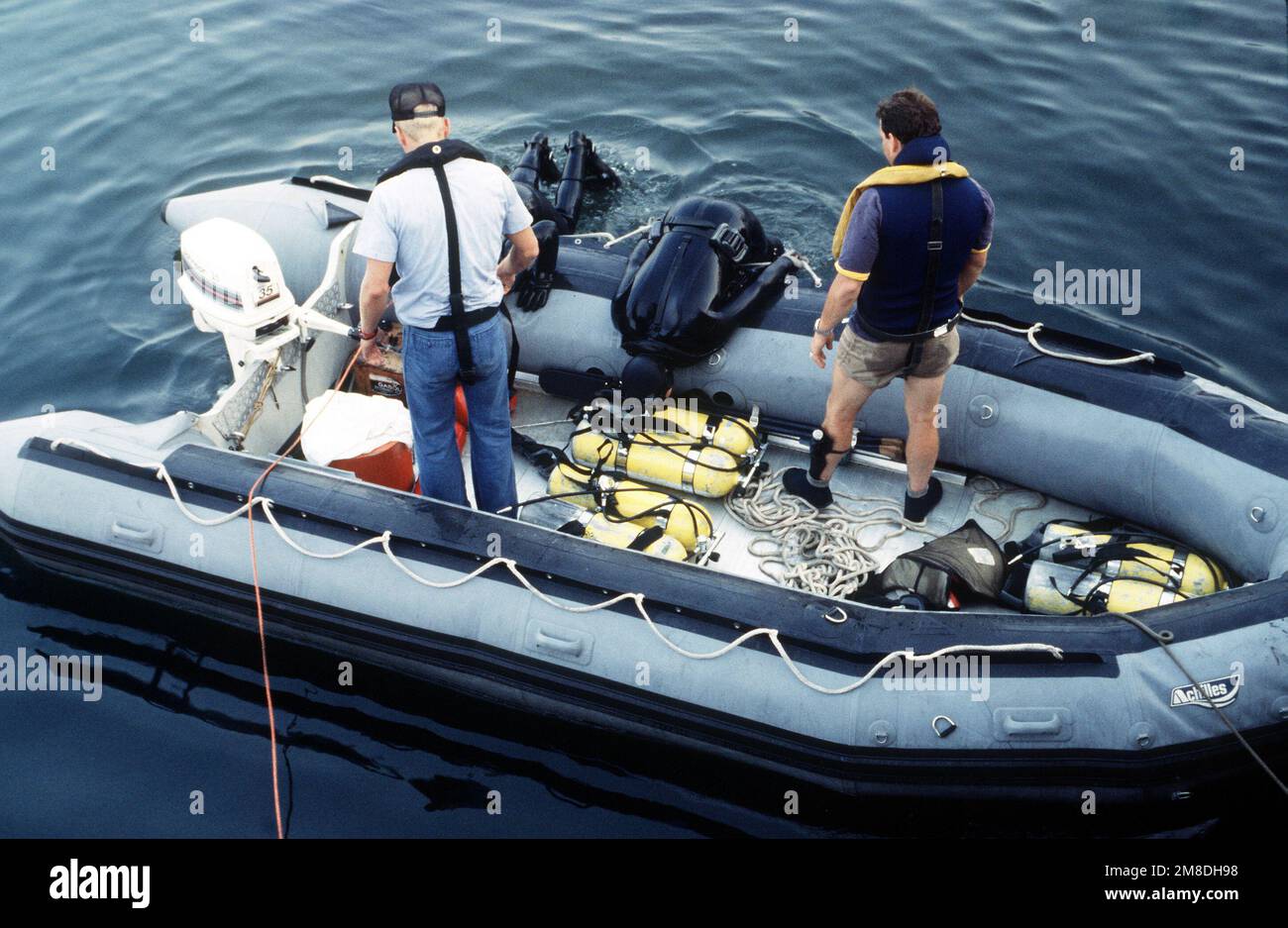 Les plongeurs de la Marine grimpent dans un bateau gonflable après avoir effectué des opérations d'entretien sous-marin sur le sous-marin de missiles stratégiques à propulsion nucléaire USS NEVADA (SSBN 733) au chantier naval de long Beach. Base: Long Beach État: Californie (CA) pays: Etats-Unis d'Amérique (USA) Banque D'Images