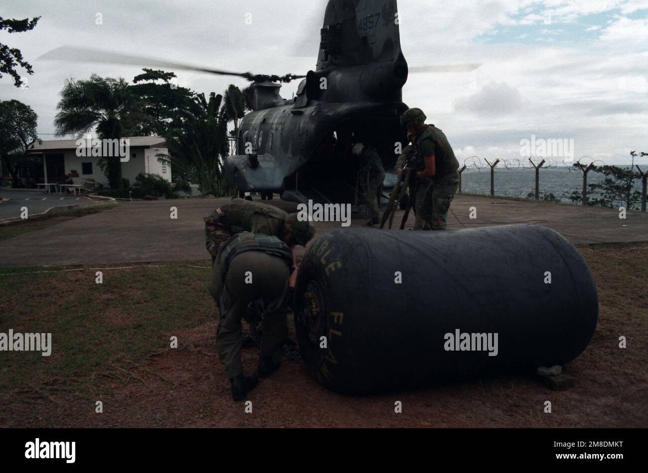 Marines désolidariser le harnais d'une poche à carburant déposée aux États-Unis Ambassade par un hélicoptère marin de taille moyenne 162 (HMM-162) CH-46E hélicoptère Sea Knight pendant l'opération Sharp Edge. L'ambassade reçoit du personnel et du soutien logistique d'un groupe amphibie prêt à l'emploi qui est en station au large de la côte du Libéria. Le groupe READY aide également à évacuer les civils pris dans la guerre civile au Libéria. Objet opération/série : BASE SHARP EDGE : Monrovia pays : Libéria (LBR) Banque D'Images Marines désolidariser le harnais d'une poche à carburant déposée aux États-Unis Ambassade par un hélicoptère marin de taille moyenne 162 (HMM-162) CH-46E hélicoptère Sea Knight pendant l'opération Sharp Edge. L'ambassade reçoit du personnel et du soutien logistique d'un groupe amphibie prêt à l'emploi qui est en station au large de la côte du Libéria. Le groupe READY aide également à évacuer les civils pris dans la guerre civile au Libéria. Objet opération/série : BASE SHARP EDGE : Monrovia pays : Libéria (LBR) Banque D'Images