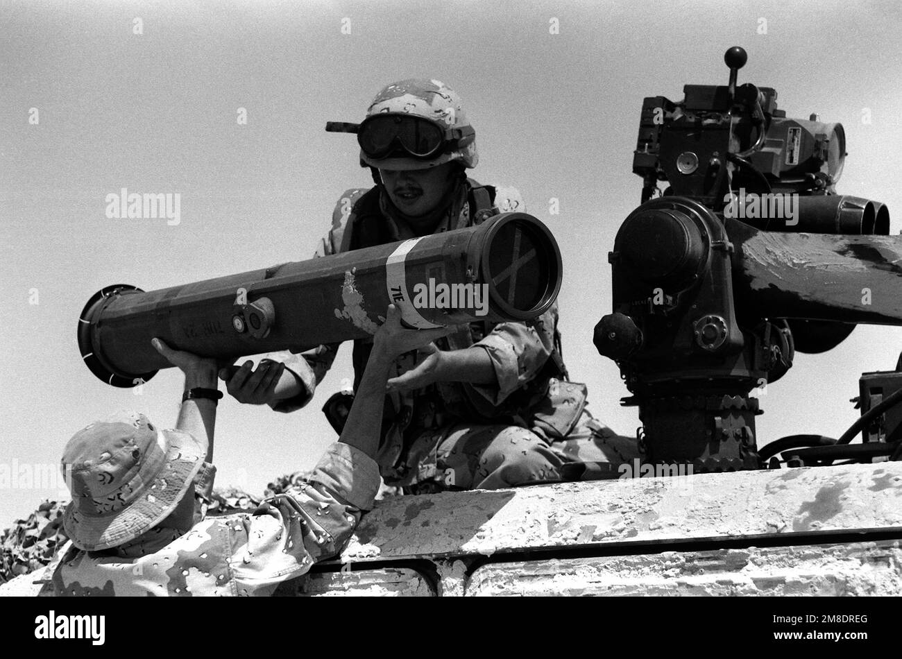 Lance CPL. T.A. Gomer, Weapons Co., 1st BN., 7th marines, est remis un projectile à charger dans un système d'arme antichar lourd à guidage optique (REMORQUAGE) lancé par tube, monté sur un véhicule à roues polyvalent M998 haute mobilité (HMMWV) pendant l'opération Desert Shield. Objet opération/série : BOUCLIER DU DÉSERT pays : Arabie saoudite (SAU) Banque D'Images Lance CPL. T.A. Gomer, Weapons Co., 1st BN., 7th marines, est remis un projectile à charger dans un système d'arme antichar lourd à guidage optique (REMORQUAGE) lancé par tube, monté sur un véhicule à roues polyvalent M998 haute mobilité (HMMWV) pendant l'opération Desert Shield. Objet opération/série : BOUCLIER DU DÉSERT pays : Arabie saoudite (SAU) Banque D'Images