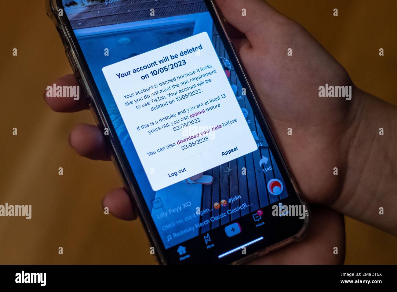 Enfant tenant un téléphone mobile avec un message de compte supprimé dans l'application TikTok. Tik Tok a interdit les comptes d'enfants de moins de 13 ans en Europe. Banque D'Images