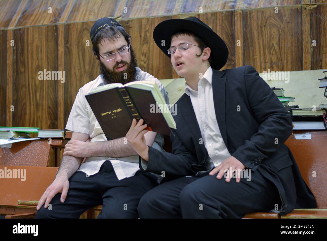 2 Lubavitcher jeunes hommes étudient un livre avec les conférences de Rebbe appelé Likkutei Sichos. Dans la synagogue principale de Chabad, 770, à Crown Heights, Brooklyn. Banque D'Images