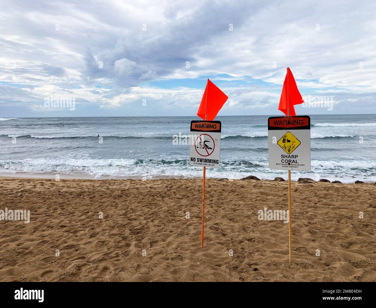 Deux panneaux d'avertissement, corail vif, pas de baignade et drapeaux d'avertissement rouges affichés sur un endroit populaire de surf à la plage de Haleiwa à Oahu Hawaii pendant la tempête hivernale. Banque D'Images