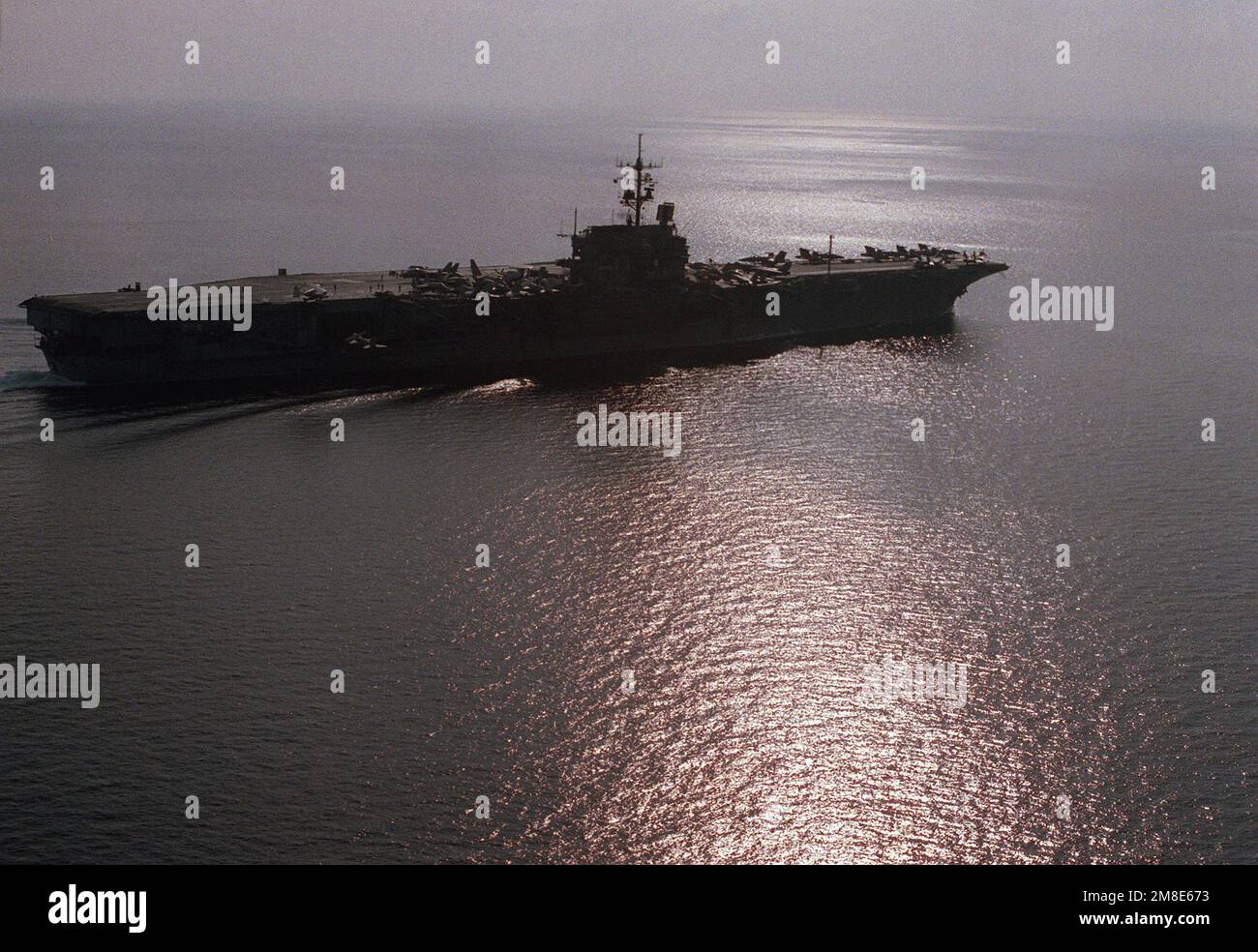 Un côté tribord du porte-avions USS SARATOGA (CV-60) se trouve dans l'ombre  tandis que le navire effectue des manœuvres pendant l'opération Desert  Shield. Sujet opération/série: BOUCLIER DU DÉSERT pays: Inconnu Photo Stock  -