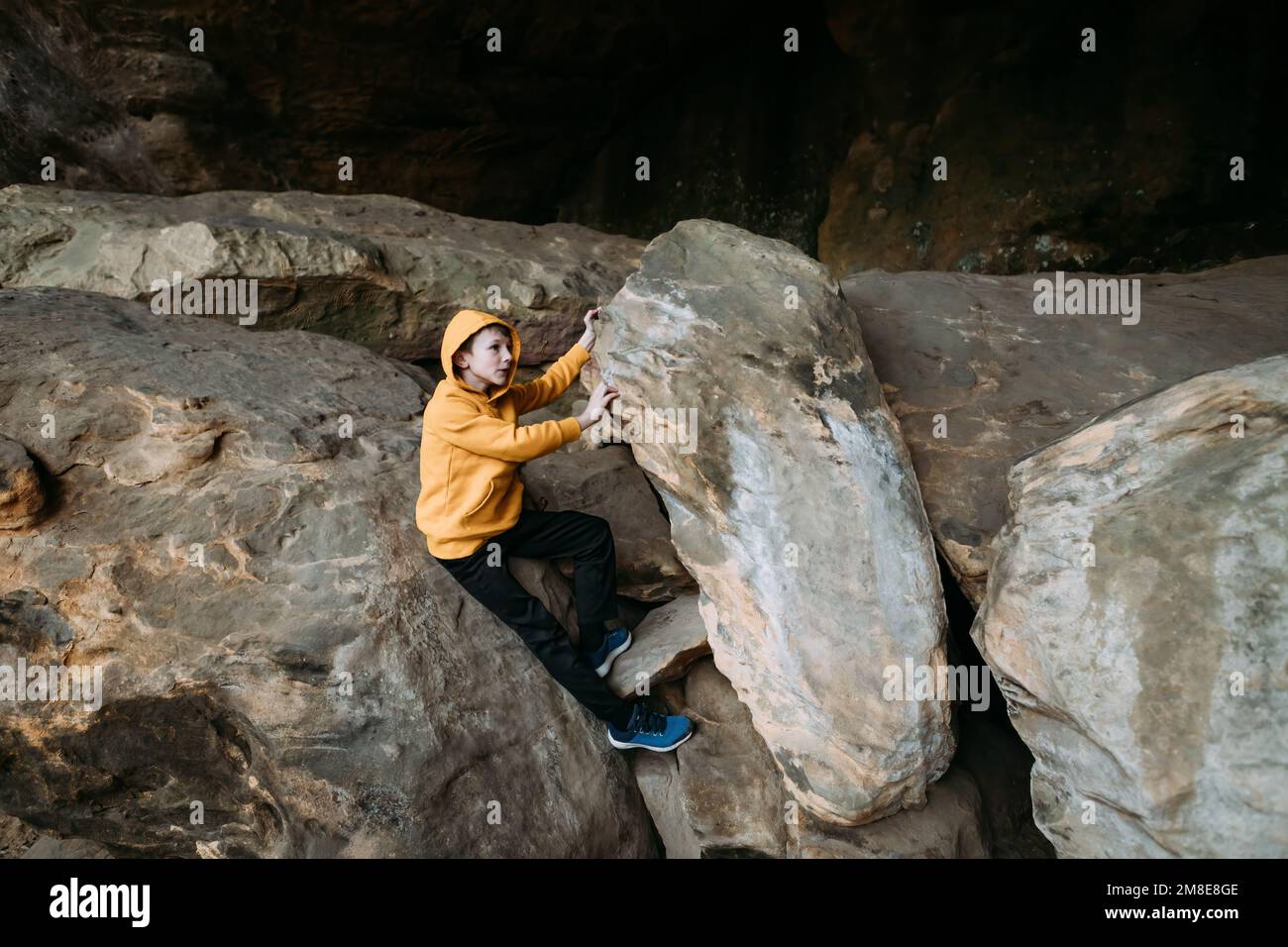 Jeune garçon explorant sur des rochers pendant la randonnée Banque D'Images