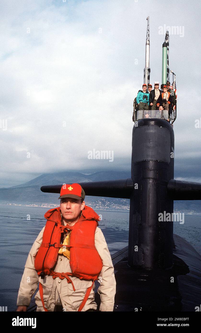 Owen C. Martin, maître de scout de la troupe scout 85, se tient sur le pont du sous-marin d'attaque nucléaire USS PHILADELPHIA (SSN 690) comme son scouts homme la voile avec le CMDR Ryan, commandant du navire. La troupe a été à bord du navire pour un séjour de 36 heures organisé par le commandant de la Sixième flotte. Base: Gaeta pays: Italie(ITA) Banque D'Images