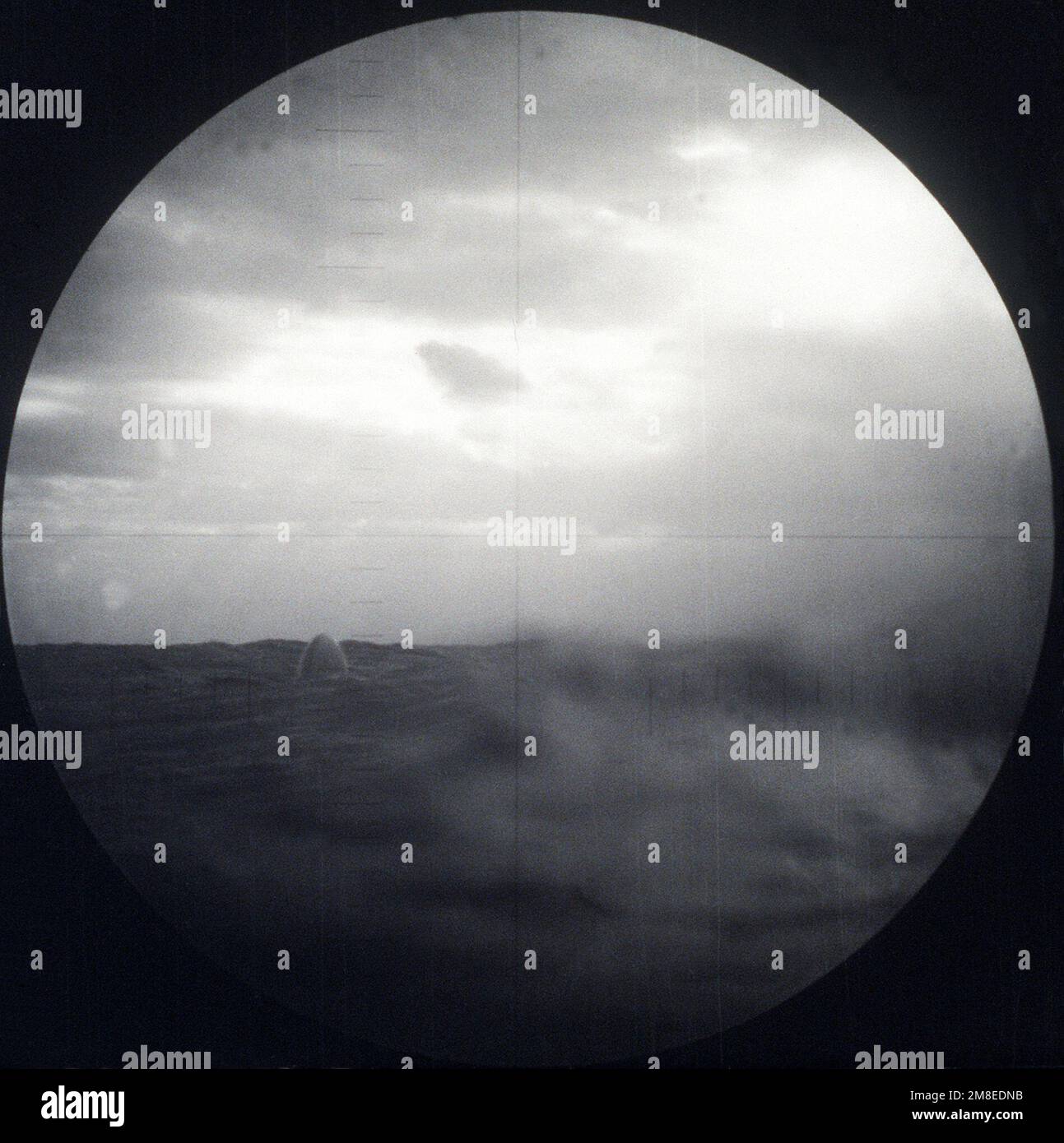 Vu à travers le périscope du sous-marin, le nez d'un missile d'attaque terrestre BGM-109 Tomahawk (TLAM) ciblé sur une position iraquienne sort de l'eau après avoir été tiré d'un tube de lancement vertical à bord du sous-marin d'attaque nucléaire USS PITTSBURGH (SSN-720) pendant l'opération Desert Storm. (Premier d'une série de neuf vues.) Sujet opération/série: TEMPÊTE DANS LE DÉSERT pays: Inconnu Banque D'Images