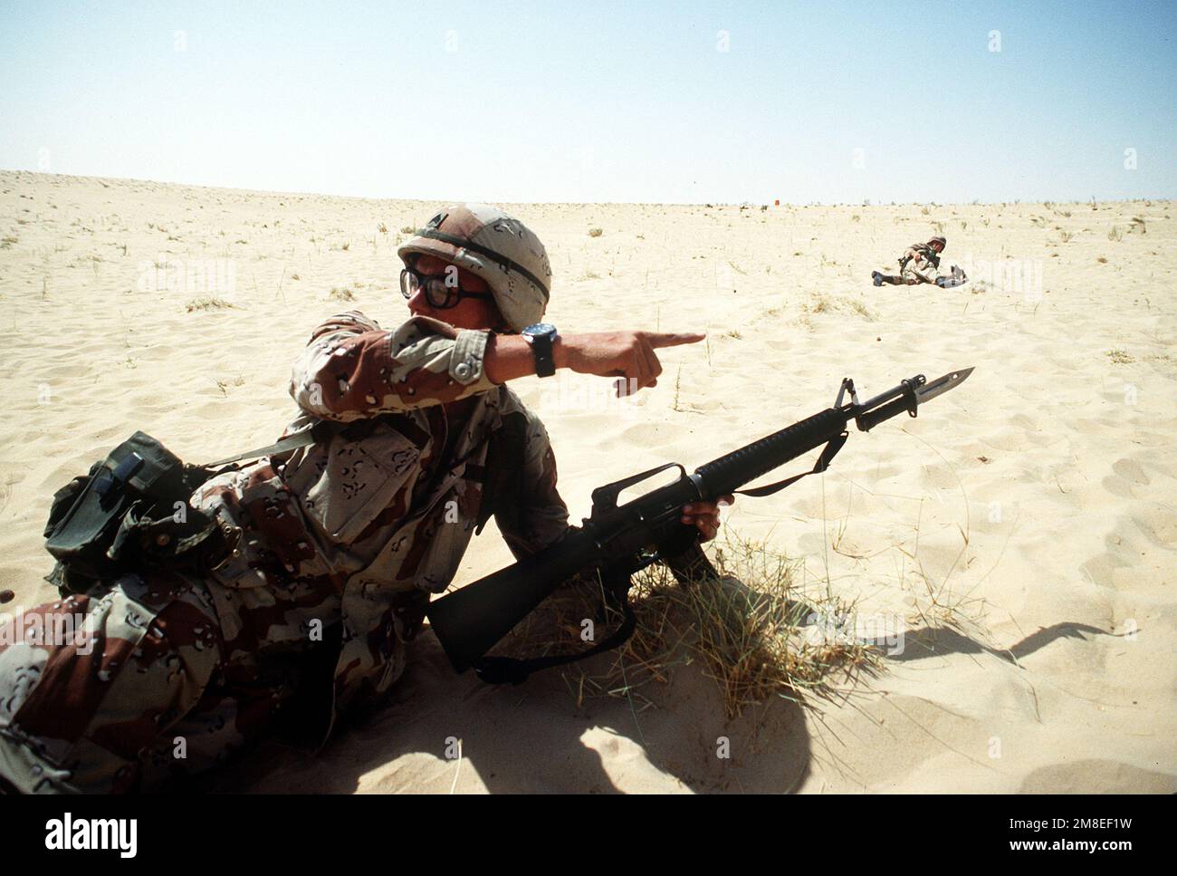 Un chef d'équipe de 1st BN., 505th Parachute Infantry Regt., 82nd Airborne Dive., dirige ses soldats par un exercice de réaction pendant l'opération Desert Shield. Le sergent est armé d'un fusil M-16A2 à baïonnette fixe. Objet opération/série : BOUCLIER DU DÉSERT pays : Arabie saoudite (SAU) Banque D'Images