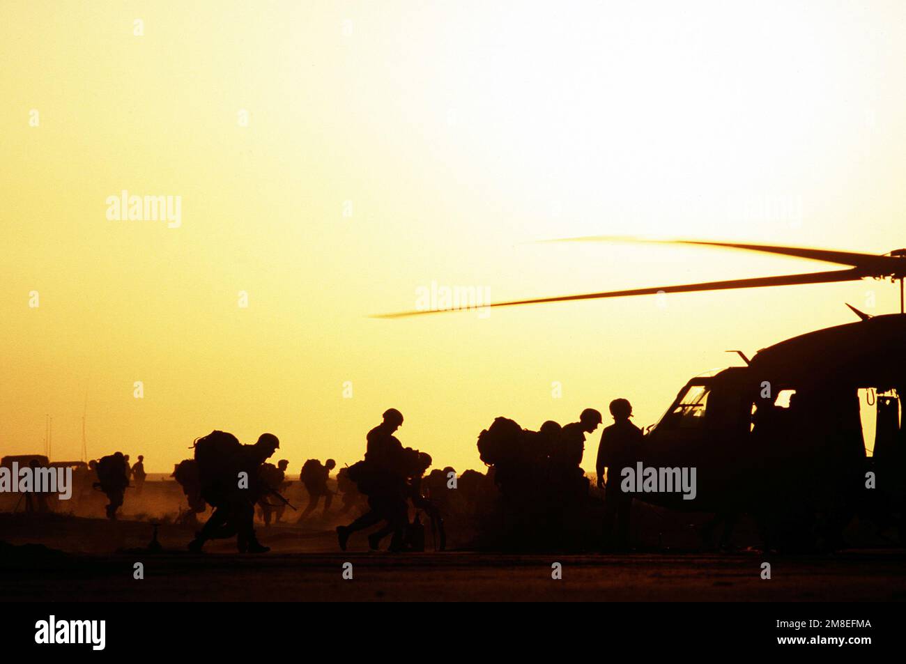 Deux groupes de soldats sont silhouettés contre le ciel lorsqu'ils sont à bord d'hélicoptères UH-60A Black Hawk (Blackhawk) pendant l'opération Desert Shield. Objet opération/série : BOUCLIER DU DÉSERT pays : Arabie saoudite (SAU) Banque D'Images