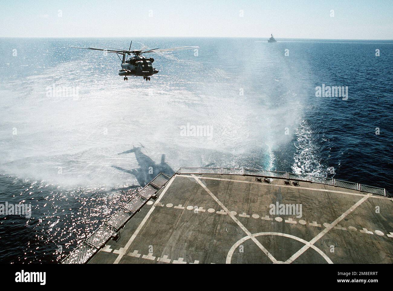 Un hélicoptère CH-53E Super Stallion débarque sur le plateau de l'hélicoptère de la flotte militaire de ravitaillement USNS JOSHUA HUMPHREYS (T-AO-188) à la suite de l'opération Desert Storm. Le destroyer de missile guidé USS WILLIAM V. PRATT (DDG-44) s'approche en arrière-plan. Sujet opération/série: TEMPÊTE DANS LE DÉSERT pays: Mer Rouge Banque D'Images