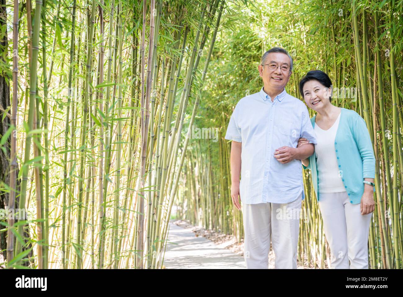 Un vieux couple marchant dans la forêt de bambou Banque D'Images