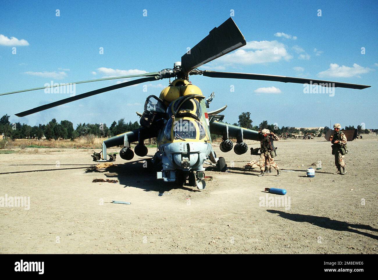Les membres de la division aéroportée de 82nd approchent d'un hélicoptère d'assaut mi-24 de Hind-D de la MIL iraquienne abandonné pendant l'opération tempête du désert. Le soldat le plus proche de l'avion porte une ceinture de munitions pour la mitrailleuse 12,7mm de type Gatling, montée sur le menton et contrôlée à distance. Objet opération/série : TEMPÊTE DANS LE DÉSERT pays : Irak (IRQ) Banque D'Images