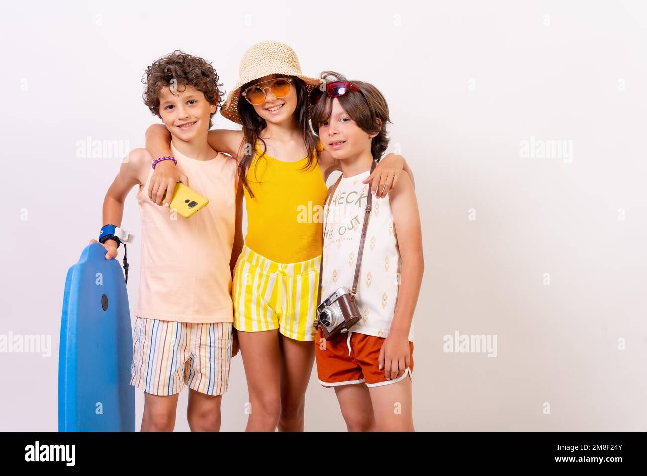 Studio de photos d'enfants souriant et s'amusant pendant les vacances d'été sur fond blanc Banque D'Images