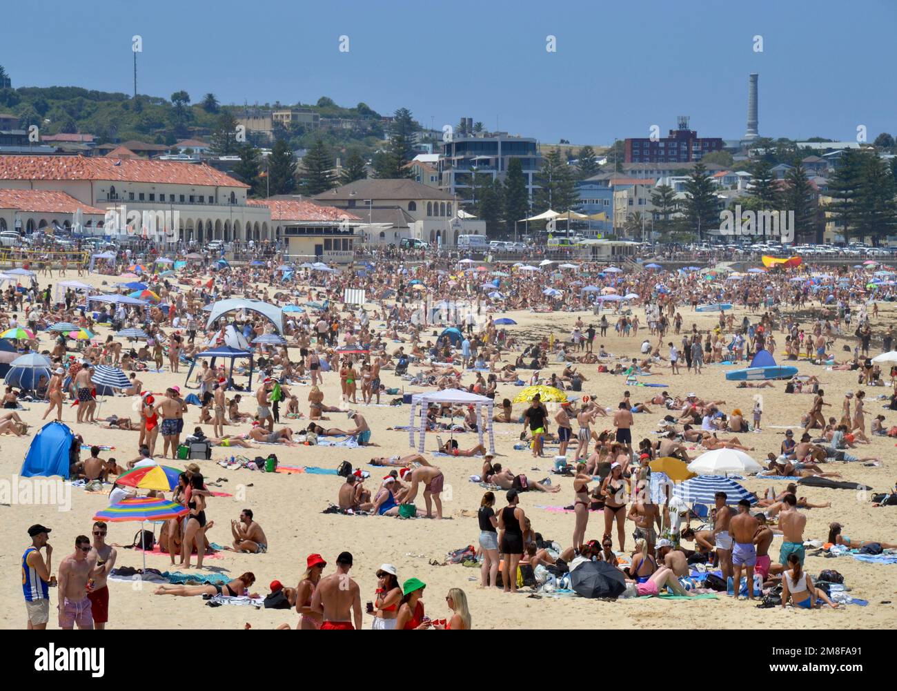 Packed Bondi Beach à l'extérieur de Sydney le jour de Noël est plein de routards vêtus de chapeaux de Santa appréciant le bronzage, la natation et le soleil australien Banque D'Images