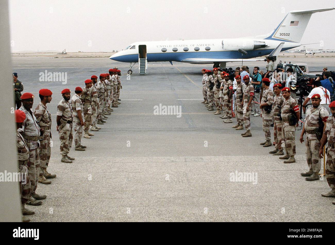 Des soldats saoudiens se tiennent en formation près d'un avion C-21A Learjet en attendant GEN. Norman Schwarzkopf, commandant en chef, États-Unis Commande centrale. Schwarzkopf a visité les forces de la coalition stationnées à la base aérienne de Riyad à la suite de l'opération tempête du désert. Objet opération/série : TEMPÊTE DANS LE DÉSERT pays : Arabie saoudite (SAU) Banque D'Images