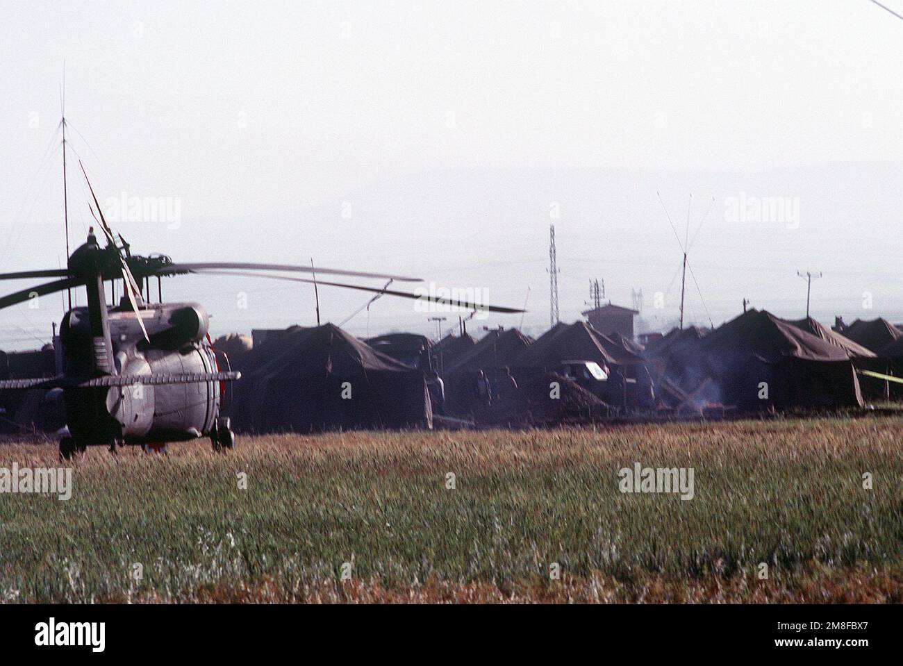 Un hélicoptère UH-60A Black Hawk (Blackhawk) se trouve dans un champ à côté de l'enceinte militaire alliée dans un camp de réfugiés. Des troupes des États-Unis et d'autres pays de la coalition sont à Silopi dans le cadre de l'opération fournir confort, un effort multinational pour aider les réfugiés kurdes dans le nord de l'Irak et le sud de la Turquie. Sujet opération/série: FOURNIR LE CONFORT base: Silopi pays: Turquie(TUR) Banque D'Images