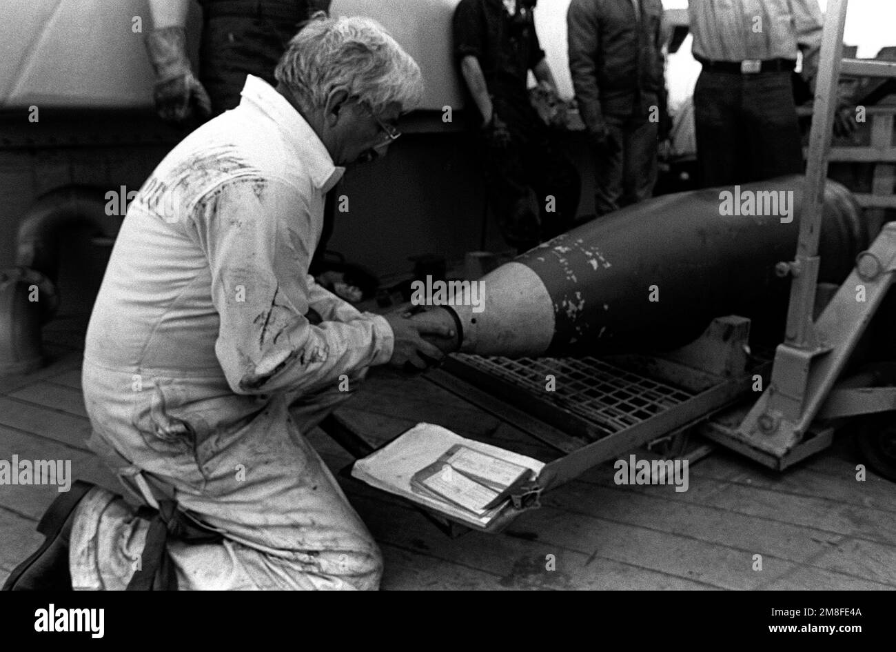 Un travailleur civil remplace la couverture de fuze d'un projectile de 16 pouces sur le pont du navire de guerre USS MISSOURI (BB-63). Des munitions sont déchargées après le retour du navire du golfe Persique à la suite du cessez-le-feu qui a mis fin à l'opération tempête du désert. Objet opération/série : TEMPÊTE DU DÉSERT base : Naval Air Station, long Beach État : Californie (CA) pays : États-Unis d'Amérique (USA) Banque D'Images