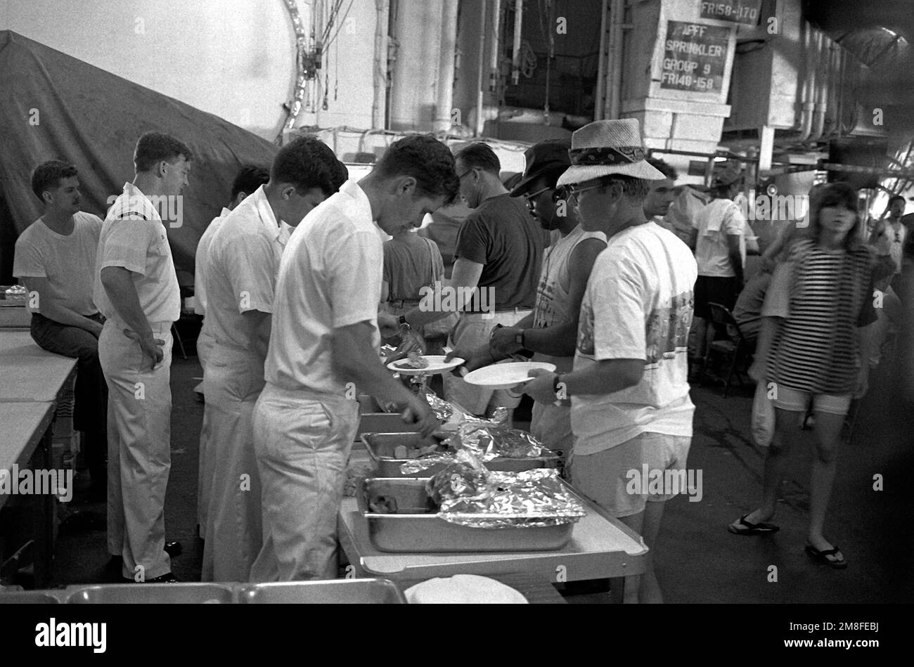 Le personnel de la Marine à bord du porte-avions USS MIDWAY (CV-41) sert un repas aux évacués de la base aérienne de Clark et de la base navale de Subic Bay. Le personnel militaire et les personnes à charge sont transportés de la région à la suite de l'éruption du mont Pinatubo, un volcan des Philippines qui a vu le jour à 10 juin pour la première fois en plus de 600 ans. Base : USS Midway (CV 41) Banque D'Images