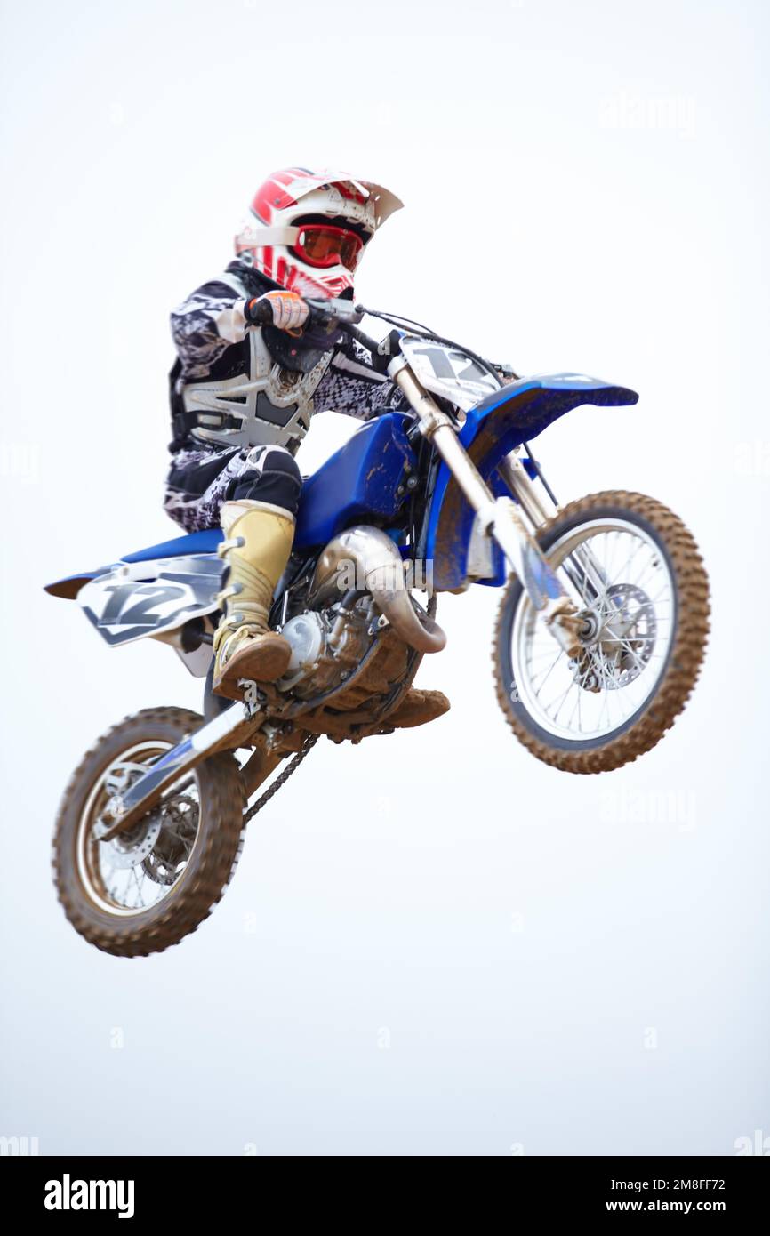 Atteindre les sommets. Un motocross en vol contre un ciel blanc. Banque D'Images