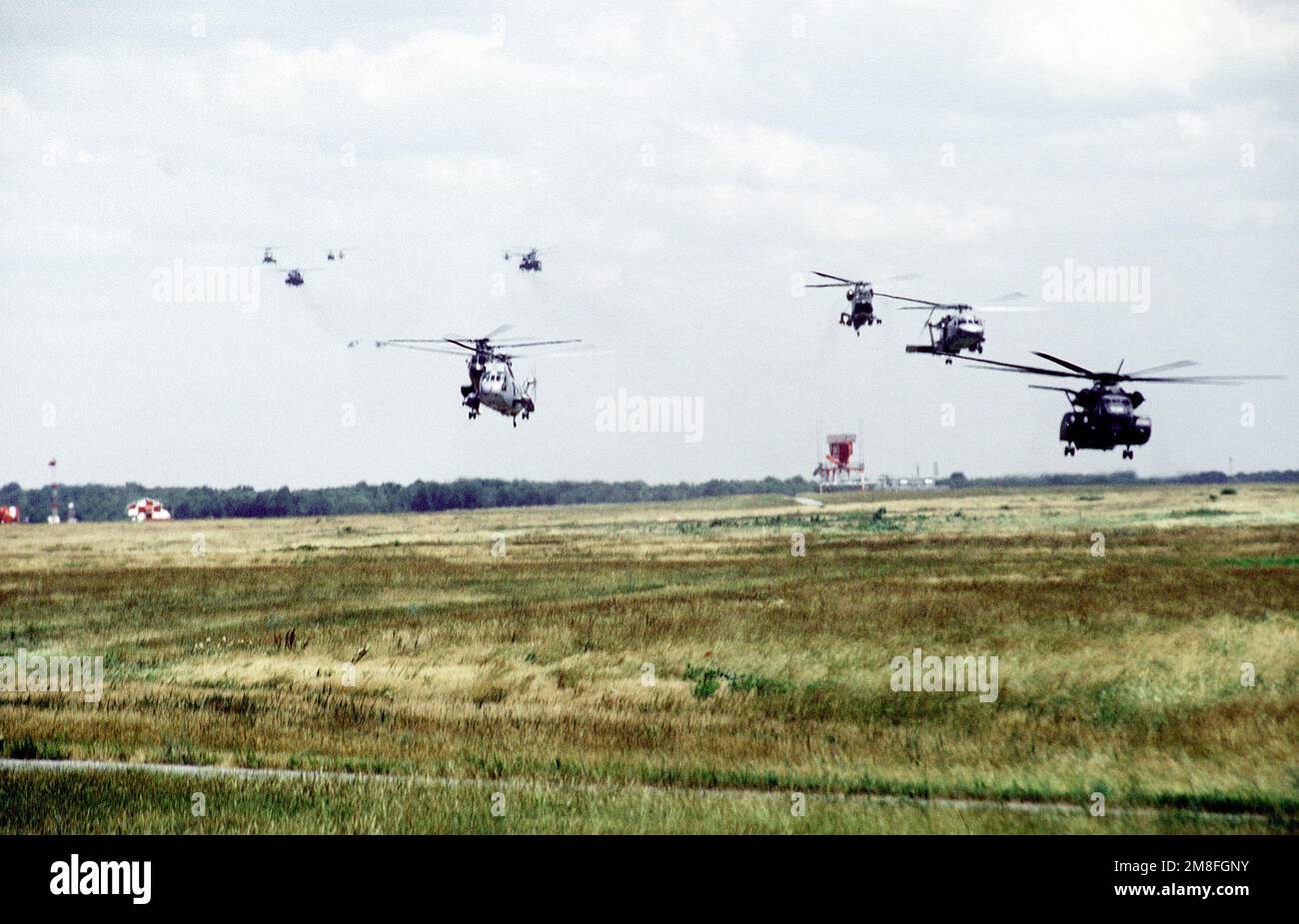 Divers hélicoptères décoller de la base pour participer à la célébration de la victoire nationale. Ils comprennent un hélicoptère SH-3 Sea King, un SH-2 Seasprite, un SH-60 Sea Hawk et un MH-53E Sea Dragon. L'événement se tient en l'honneur de la libération du Koweït par les forces alliées au cours de l'opération tempête du désert. Objet opération/série: DESERT STORM base: Andrews Air Force base État: Maryland (MD) pays: États-Unis d'Amérique (USA) Banque D'Images