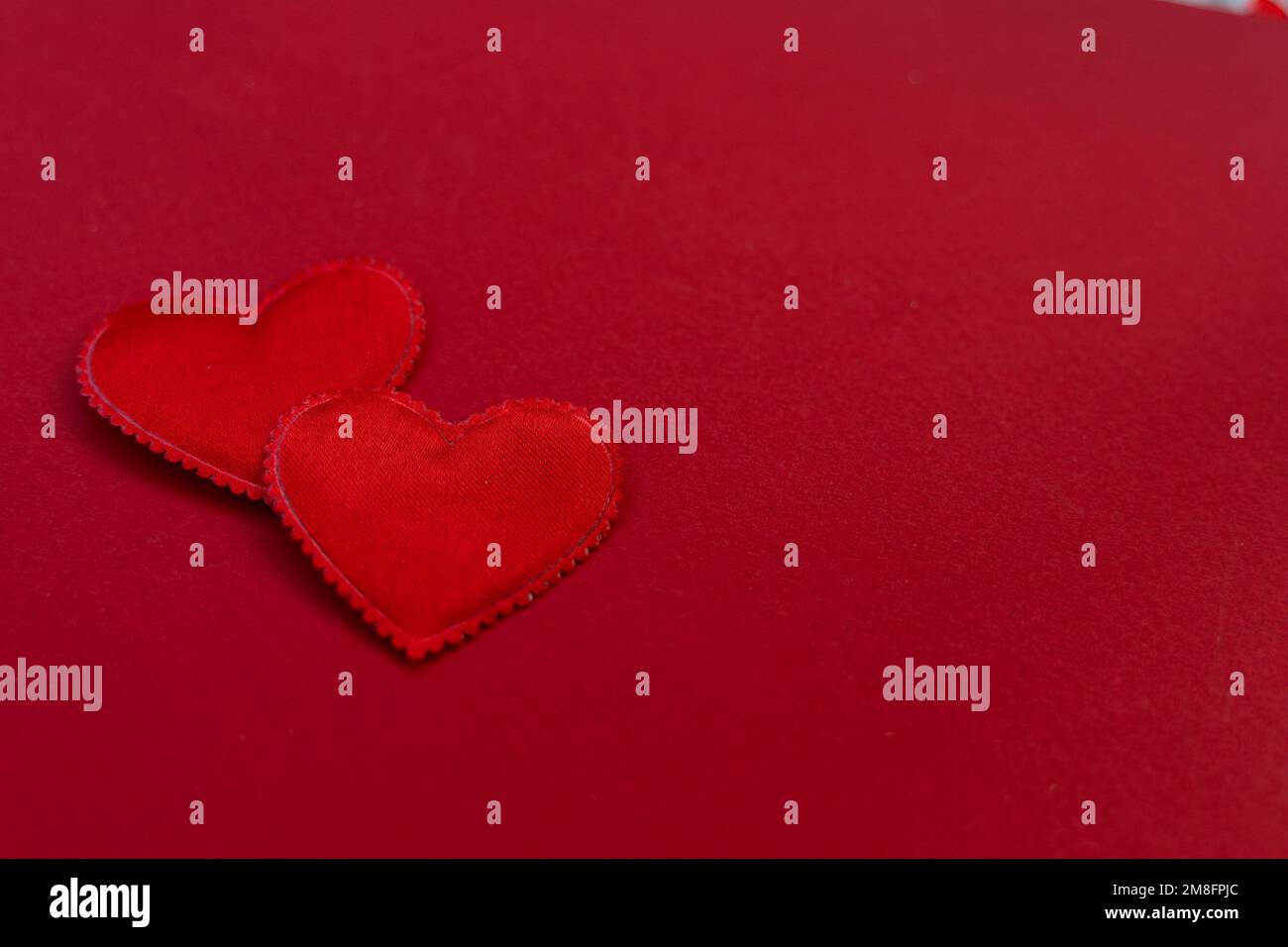 Toile de fond pour le motif de la Saint-Valentin. sur un fond texturé rouge satin 2 coeurs. concept de la saint-valentin Banque D'Images