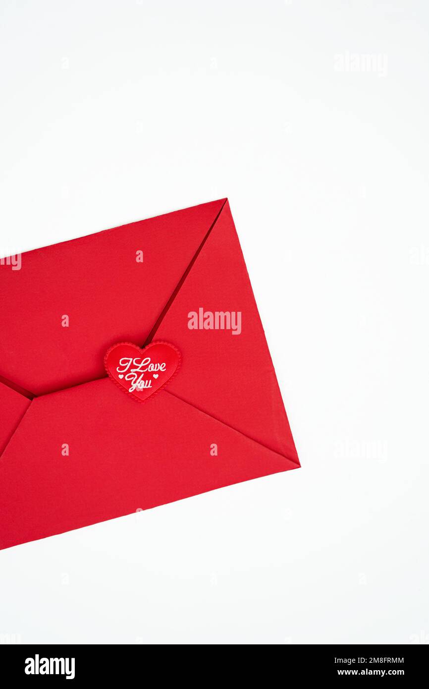 Sur fond blanc vertical, une enveloppe rouge avec un coeur rouge sur laquelle est écrit en blanc Je t'aime concept Saint-Valentin Banque D'Images