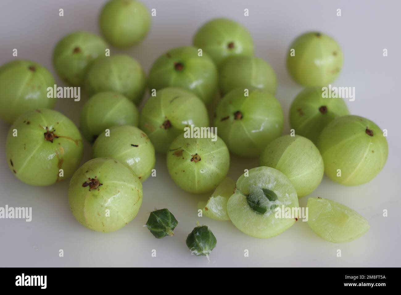 Les groseilles à maquereau d'Amala ou d'Inde sont de petits fruits nutritifs produits à partir de l'arbre des groseilles à maquereau. Il a des utilisations culinaires et de médecine à base de plantes. Prise de vue sur fond blanc Banque D'Images