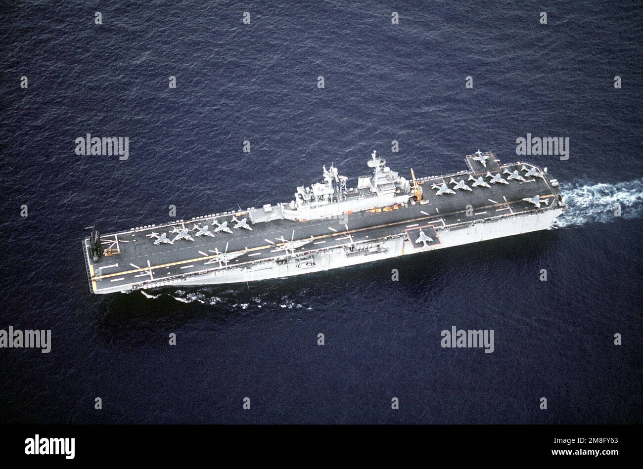 Vue aérienne du port du navire d'assaut amphibie USS WASP (LHD-1) en cours. Sur le pont de vol Wasps se trouvent 14 avions AV-8B Harrier, deux hélicoptères SH-3 Sea King et, sur l'arc tribord, un hélicoptère CH-53E Super Stallion. Pays: Mer méditerranée (MED) Banque D'Images