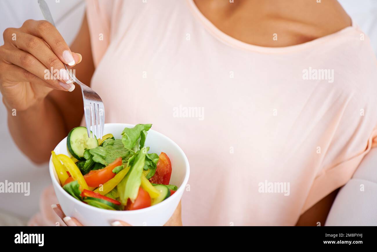 Régalez vos papilles. une jeune femme appréciant une salade à la maison. Banque D'Images