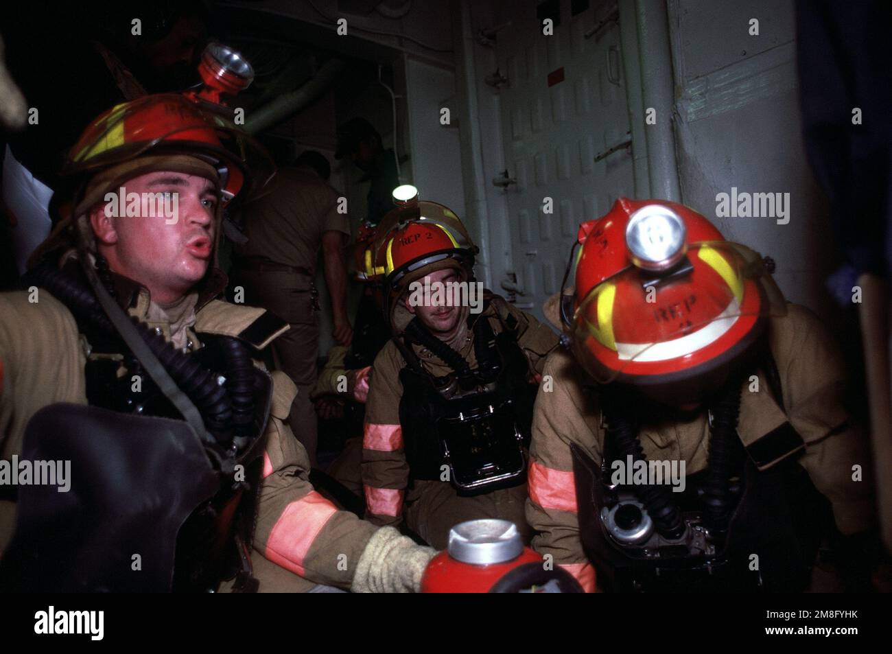 Les membres d'une partie de lutte contre l'incendie, chacun équipé d'un appareil respiratoire à oxygène (OBA) en position de veille, participent à un exercice de lutte contre l'incendie à bord du navire-citerne USS BARNSTABLE COUNTY (LST-1197). Le navire est en croisière d'entraînement en Afrique de l'Ouest en 1991. Pays: Océan Atlantique (AOC) Banque D'Images