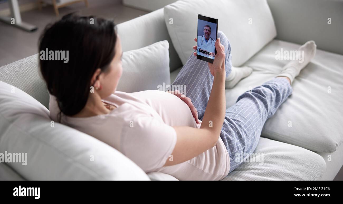Femme enceinte utilisant un appel vidéo en ligne avec Doctor sur un téléphone mobile Banque D'Images