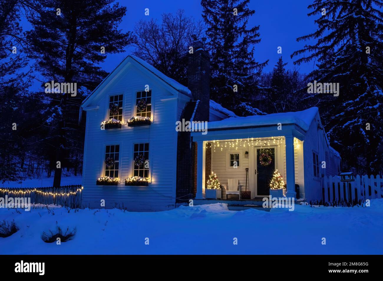 Maison historique de 1860 John H. Smith décorée avec des lumières de Noël et des arbres de Noël sur la véranda avant prise pendant l'heure bleue en début de matinée. Banque D'Images