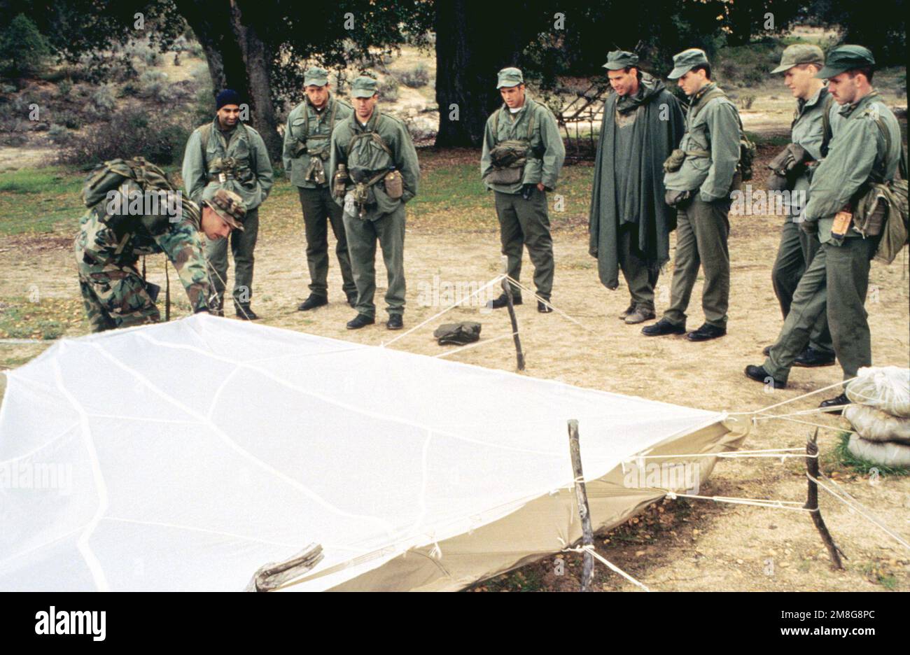 Un instructeur de l'école SERE (Survival, Escape, Resistance & Evasion) montre aux élèves comment faire un abri de leur parachute et de ses enveloppes. La classe est enseignée aux étudiants affectés à des zones potentiellement hostiles où ils pourraient rencontrer un environnement hostile. (Image dupliquée, voir aussi DNST9700134). Base: Warner Springs État: Californie (CA) pays: États-Unis d'Amérique (USA) Banque D'Images