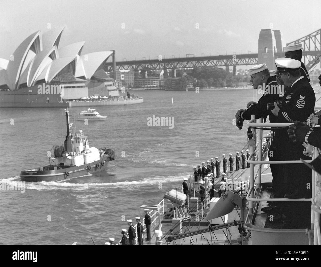 Un remorqueur commercial vient aux côtés des États-Unis Le navire amiral de la septième flotte USS BLUE RIDGE (LCC-19) en préparation à l'amarrage. La BLUE RIDGE effectue une visite portuaire pour commémorer le 50th anniversaire de la bataille de la mer de Corail. Base : Sydney Harbour State : Nouvelle-Galles du Sud pays : Australie (AUS) Banque D'Images