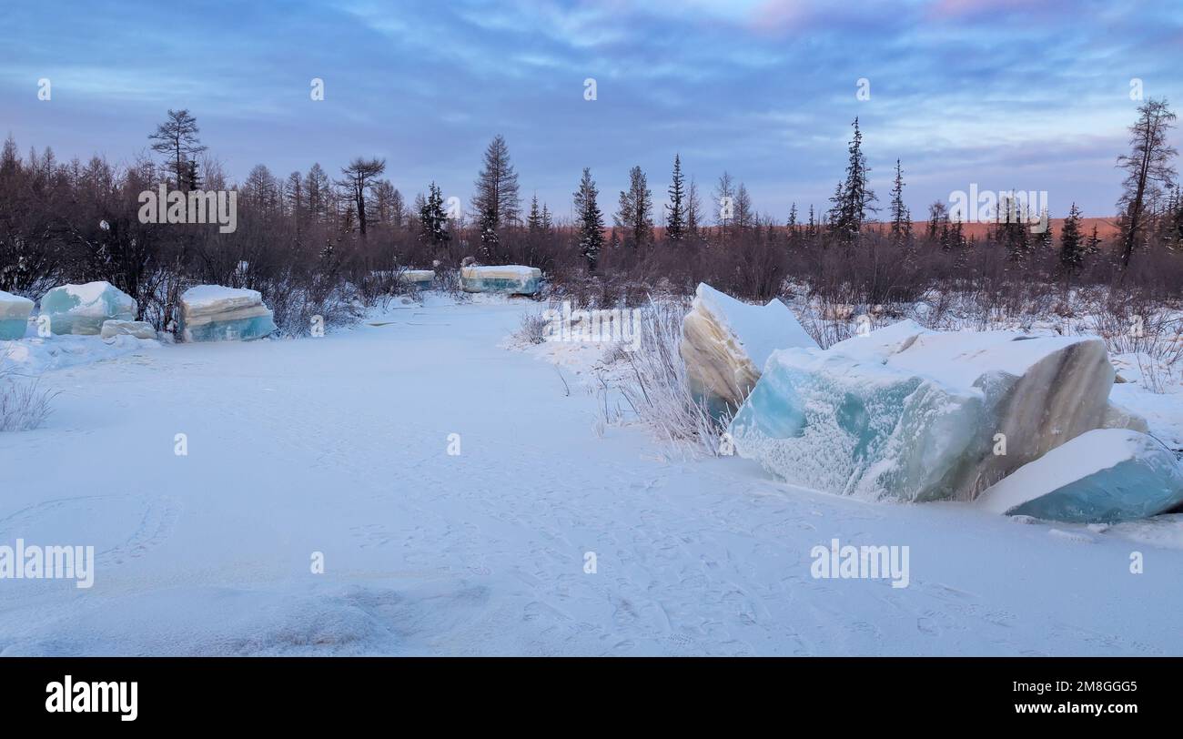 Vallée de la rivière Berkakit dans le sud de Yakutia avec des blocs de glace turquoise superposée. Paysage de soirée d'hiver. Banque D'Images