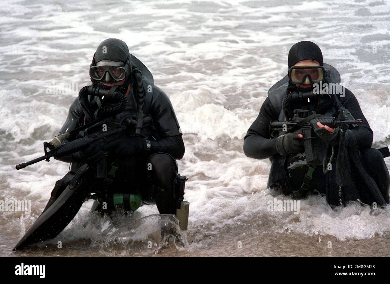 Portant des engins de plongée et armés de carbines M-4, membres d'un U.S. L'équipe Marine-Air-Land (SEAL) émerge de l'eau lors d'une démonstration de presse. Base: Base navale amphibie, Coronado État: Californie (CA) pays: Etats-Unis d'Amérique (USA) Banque D'Images Portant des engins de plongée et armés de carbines M-4, membres d'un U.S. L'équipe Marine-Air-Land (SEAL) émerge de l'eau lors d'une démonstration de presse. Base: Base navale amphibie, Coronado État: Californie (CA) pays: Etats-Unis d'Amérique (USA) Banque D'Images