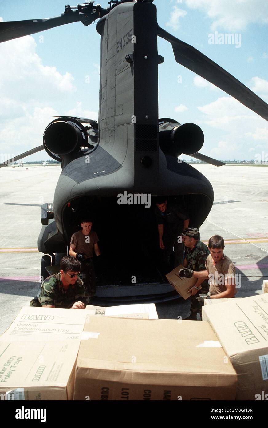 Les gardes-côtes nationaux chargent des provisions de secours dans un hélicoptère CH-47 Chinook à la station aérienne de la Garde côtière d'OPA-Locka pour distribution à la base aérienne de Homestead et aux zones environnantes endommagées pendant l'ouragan Andrew. La tempête a frappé la région de 24 août. Base: OPA Locka État: Floride (FL) pays: Etats-Unis d'Amérique (USA) Banque D'Images