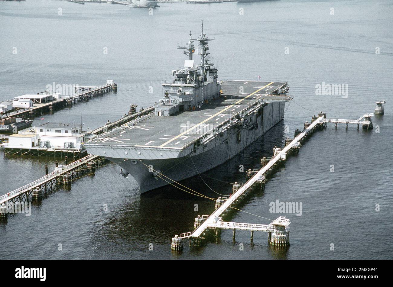Vue sur l'arc du port du navire d'assaut amphibie USS WASP (LHD-1) amarré dans un berceau de dépermage sur la rivière Elizabeth. Des bobines de déperming ont été posées sur le pont. Les bobines, lorsqu'elles sont alimentées, réduisent le magnétisme permanent du navire, contribuant ainsi à protéger le navire des mines magnétiques et des torpilles. Base: Norfolk État: Virginie (va) pays: États-Unis d'Amérique (USA) Banque D'Images