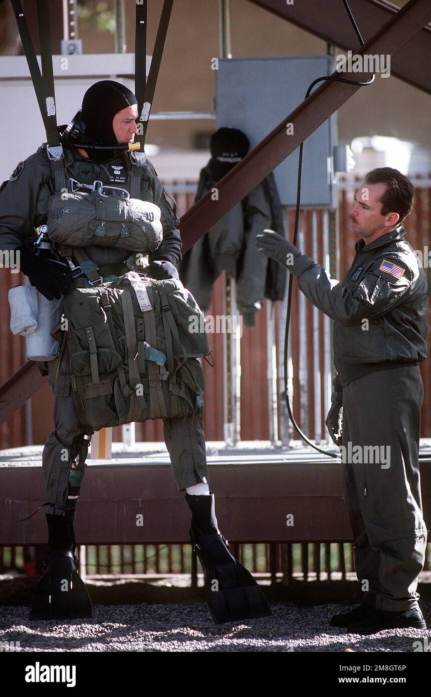 Un étudiant en parasauvetage, équipé d'un parachute et d'un équipement de survie, s'entraîne sur un harnais suspendu pour une prochaine chute de parachute à l'école de formation Pararescue continuation. Base: Kirtland Air Force base État: Nouveau Mexique (NM) pays: Etats-Unis d'Amérique (USA) Banque D'Images