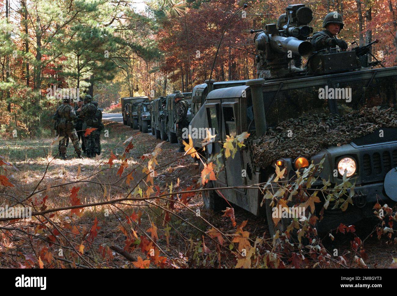 Un convoi de M998 véhicules polyvalents à roues haute mobilité (HMMWV) est stationné dans une colonne sur le côté d'une route dans une zone boisée. Le plomb M998 a un équipage marin avec une mitrailleuse M60 et une arme antichar M151. Un petit groupe de Marines se converse dans la région. Base : base du corps marin, Camp Lejeune État : Caroline du Nord (NC) pays : États-Unis d'Amérique (USA) Banque D'Images Un convoi de M998 véhicules polyvalents à roues haute mobilité (HMMWV) est stationné dans une colonne sur le côté d'une route dans une zone boisée. Le plomb M998 a un équipage marin avec une mitrailleuse M60 et une arme antichar M151. Un petit groupe de Marines se converse dans la région. Base : base du corps marin, Camp Lejeune État : Caroline du Nord (NC) pays : États-Unis d'Amérique (USA) Banque D'Images