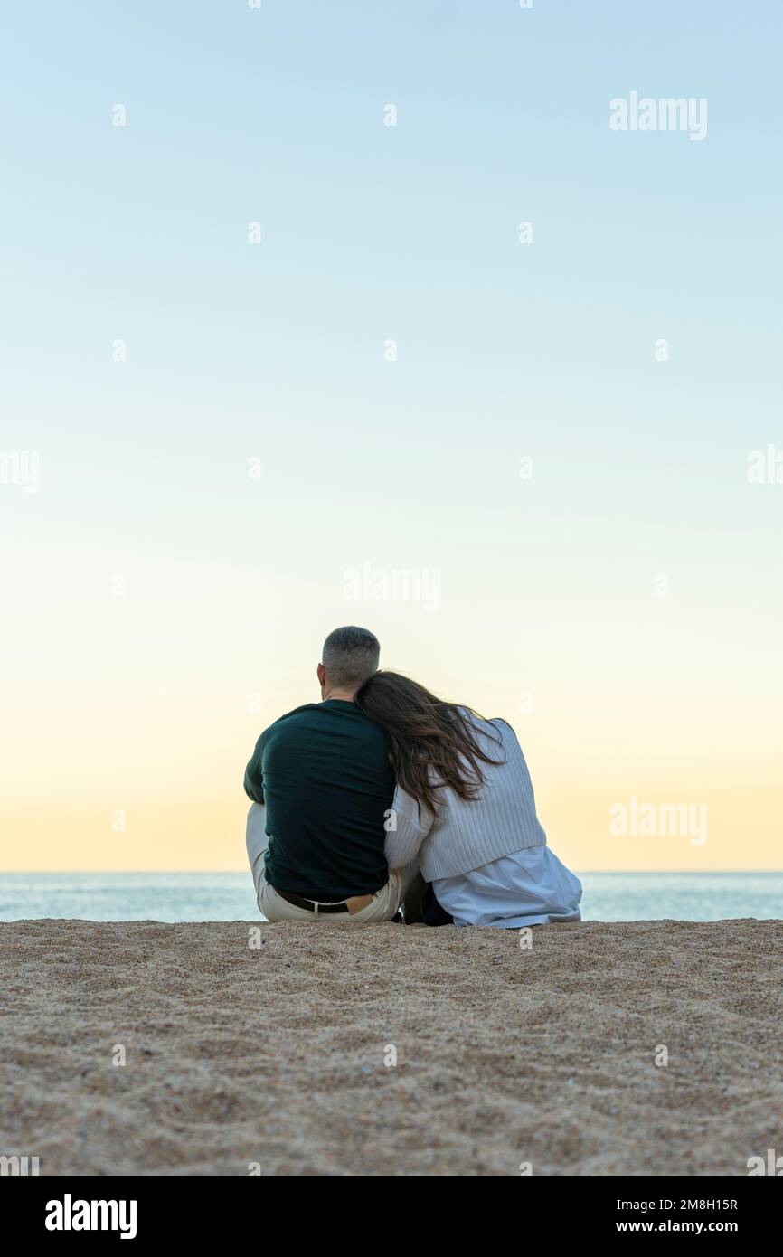 Couple amoureux très proche ensemble sur le sable de la plage Banque D'Images