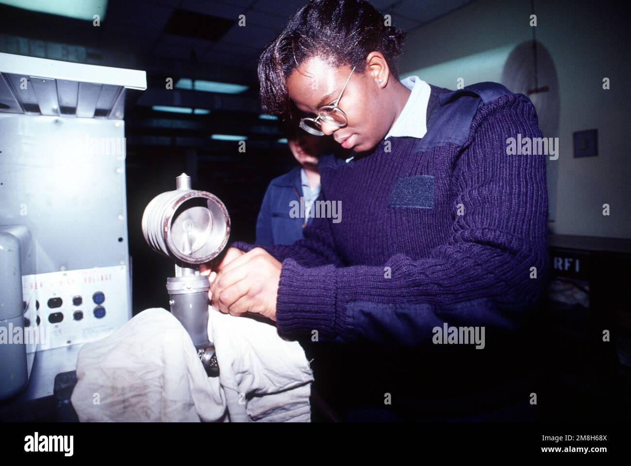 Aviation Electracian's Mate Third Class (AE3) Dionne Rohler maintient le fil de sécurité en place lorsqu'elle forme d'autres membres du personnel. Elle est rattachée à la division avionique, Service de maintenance intermédiaire de l'aéronef, Station aérienne navale de Sigonella. Base: Naval Air Station, Sigonella État: Sicile pays: Italie (ITA) Banque D'Images