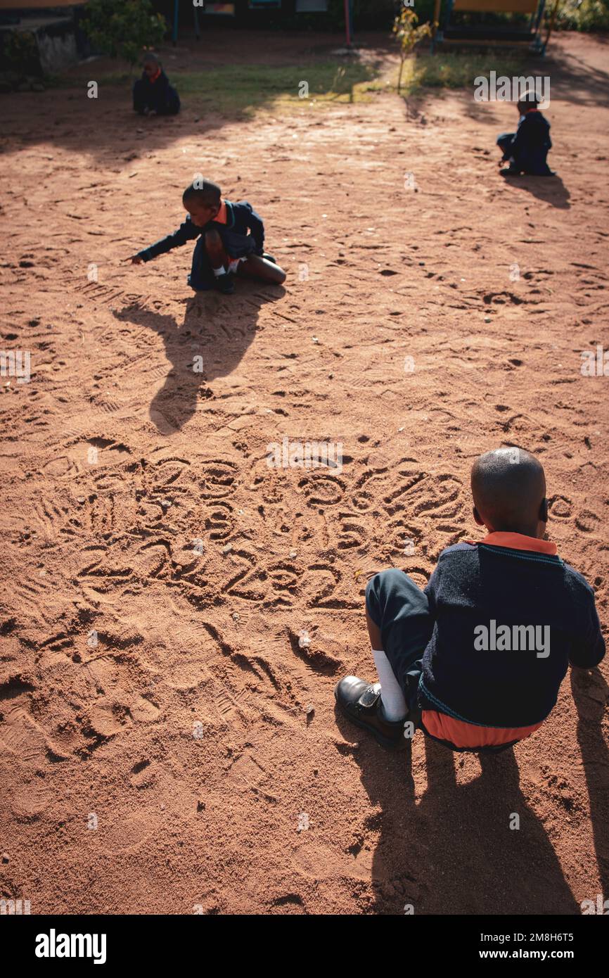 29.03.2022 Kisesa, Mwanza, Tanzanie, enfants jouant et étudiant des nombres avec du sable Banque D'Images