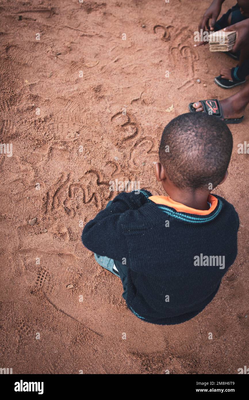 29.03.2022 Kisesa, Mwanza, Tanzanie, enfants jouant et étudiant des nombres avec du sable Banque D'Images