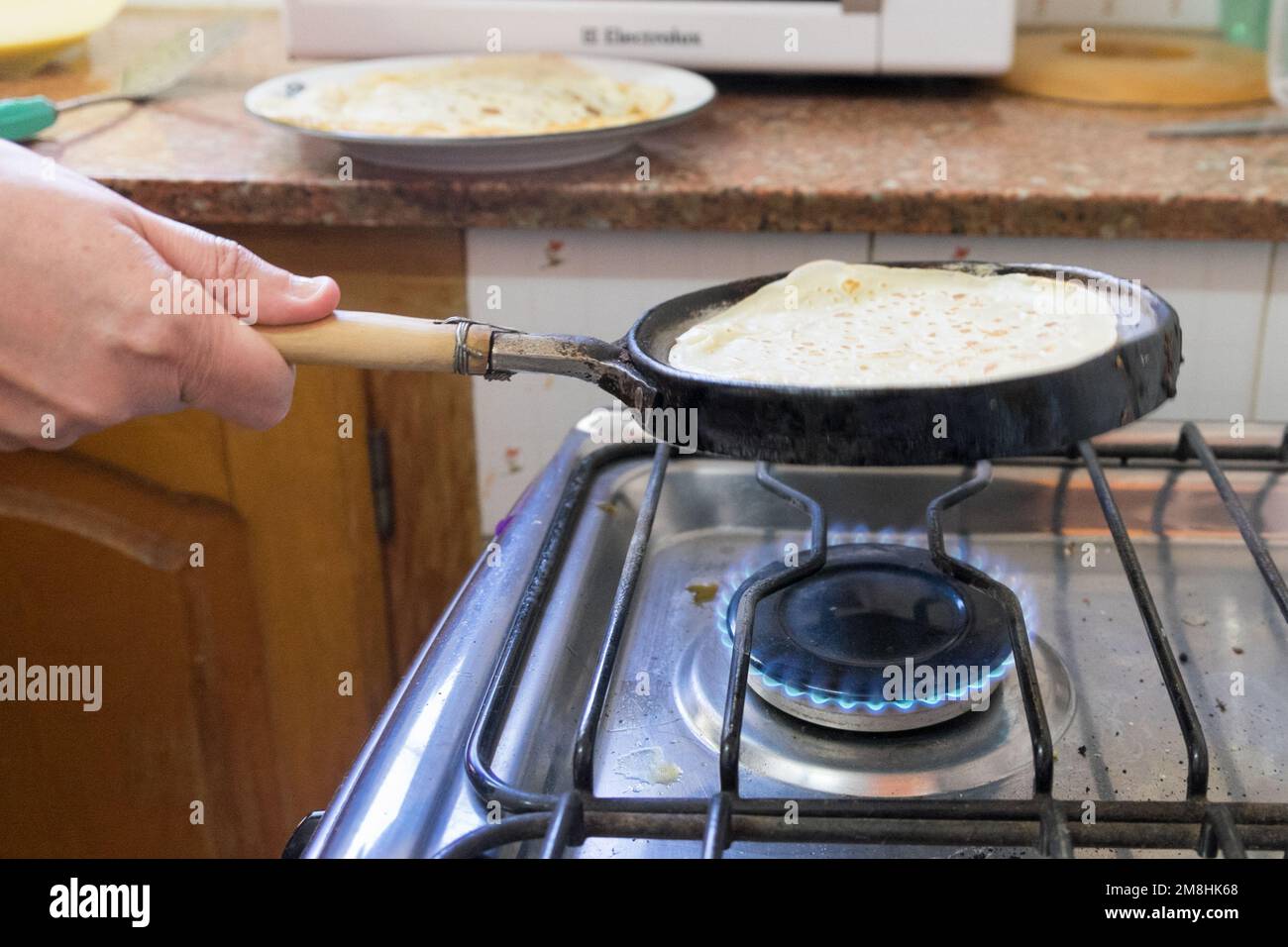 femme préparant le mélange de farine et d'eau pour faire des crêpes Banque D'Images